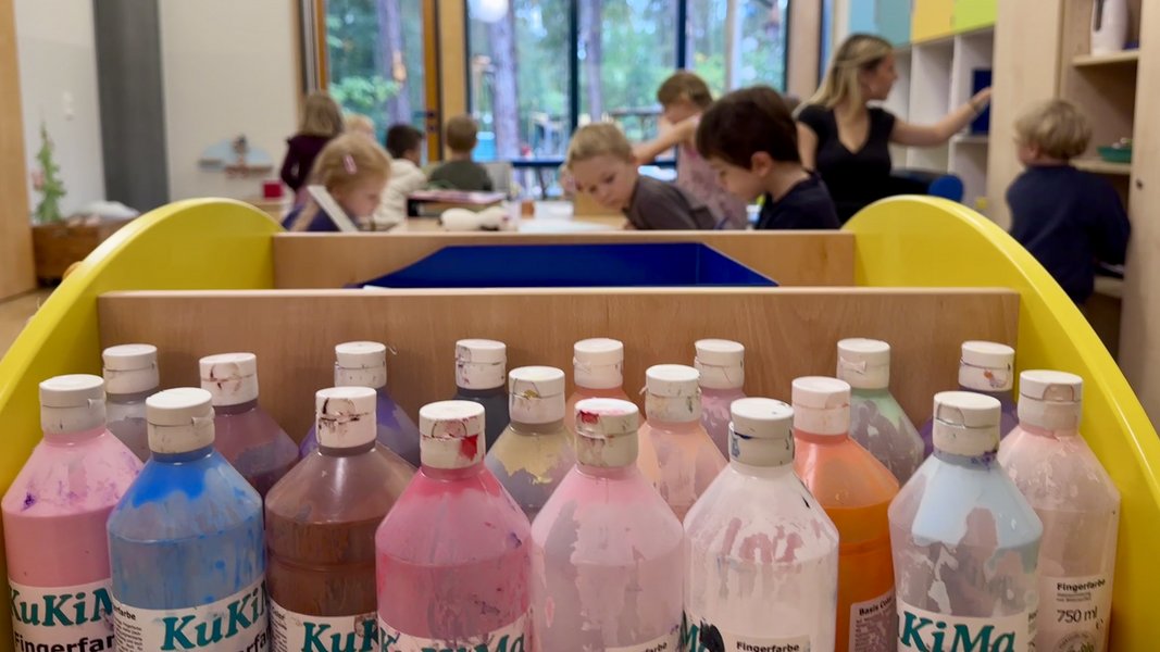 ältere Kitakinder malen am Tisch