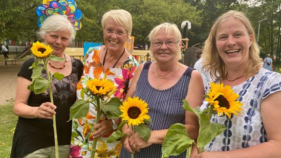 Vier Damen mit Blumen in der Hand