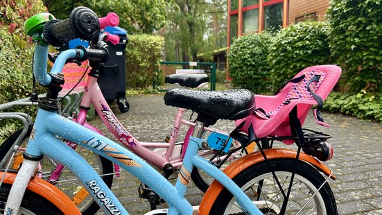 Kinderfahrräder in Fahrradständern vor der Kita