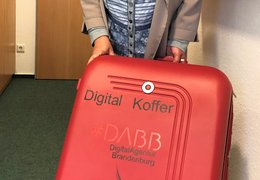 Roter Koffer mit digitalen Helfern