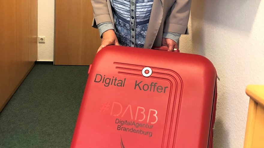 Roter Koffer mit digitalen Helfern