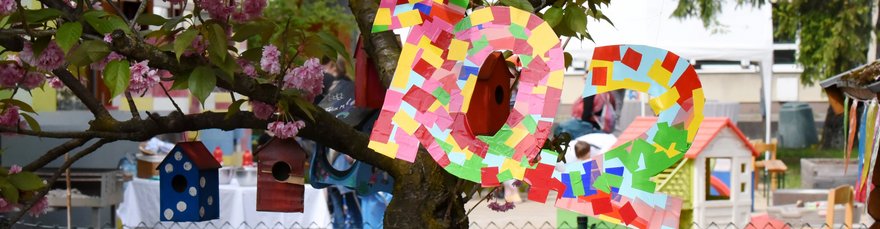 Selbstgebastelte 10+2 hängt im Garten der Kita