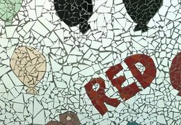 Ein Wand-Mosaik aus bunten Plättchen mit bunten Luftballons und dem Schriftzug "Red"