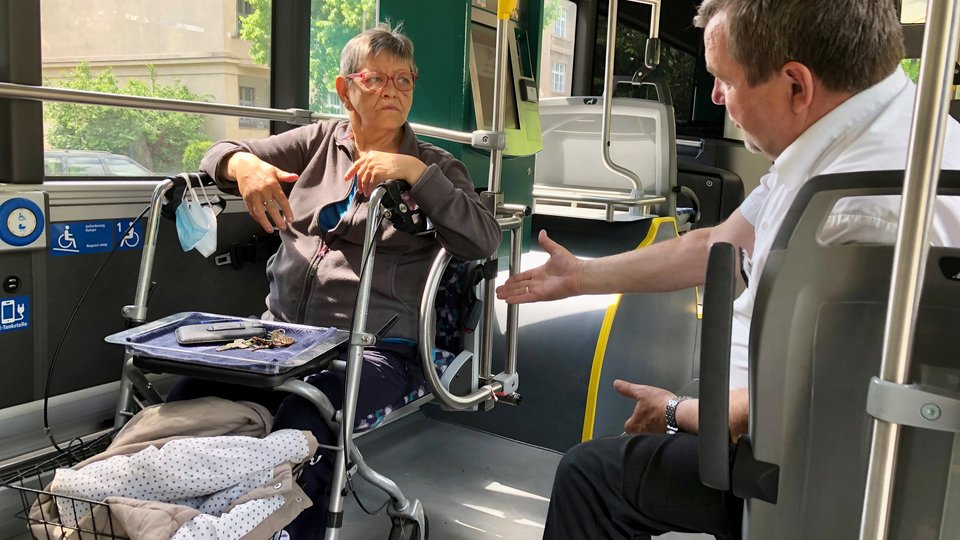 Seniorin beim Mobilitätstraining im Bus mit Trainer