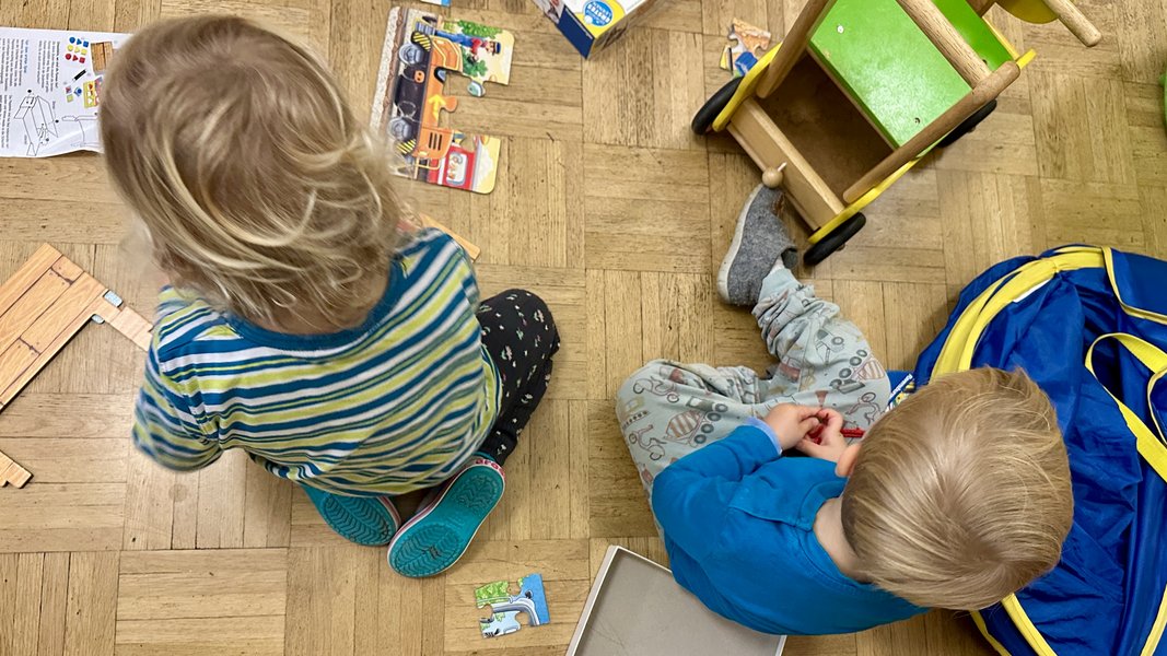Kinder spielen und puzzeln auf Fußboden im Raum