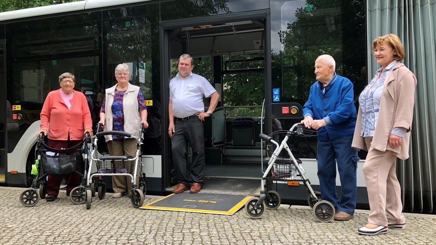 Gruppe von Teilnehmenden vor dem Bus