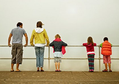 Familie steht an einem Geländer