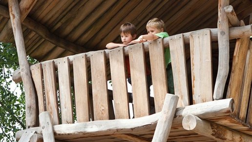 Kinder spielen auf Holzgerüst